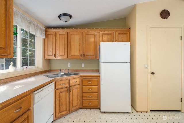 kitchen featuring white appliances, vaulted ceiling, and sink