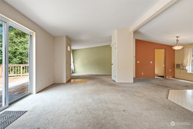 unfurnished living room featuring cooling unit, a textured ceiling, light carpet, and vaulted ceiling with beams