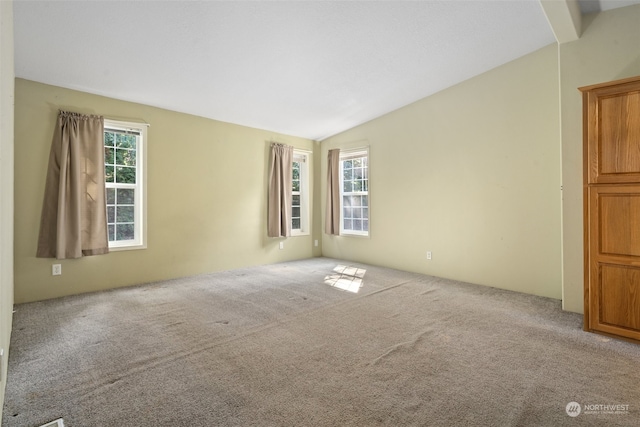 carpeted empty room with vaulted ceiling