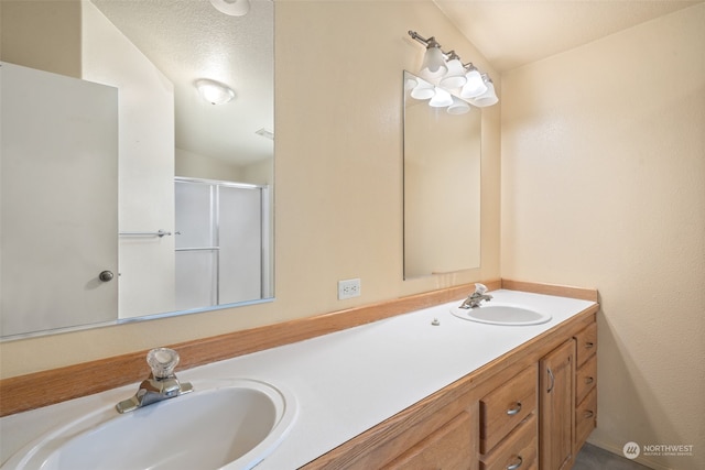 bathroom with walk in shower, a textured ceiling, and vanity