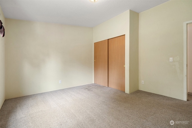 unfurnished bedroom featuring a closet, a textured ceiling, and carpet floors