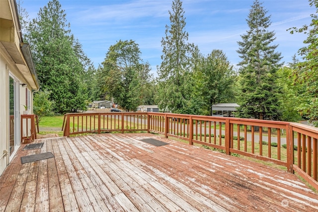 deck featuring a yard and a storage shed