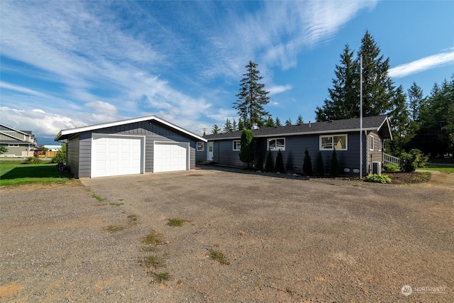 ranch-style home featuring a detached garage and an outbuilding