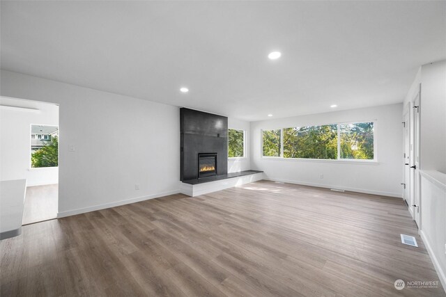 unfurnished living room with light wood-type flooring and a fireplace