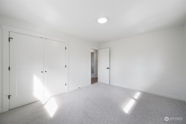 unfurnished bedroom featuring a closet and light carpet