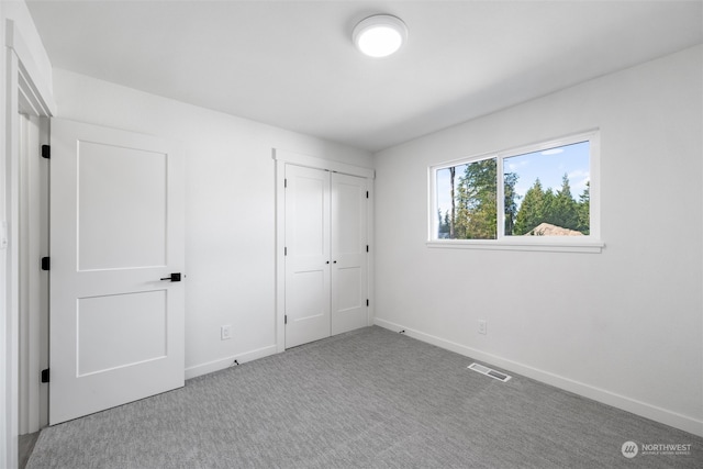 unfurnished bedroom featuring carpet flooring and a closet