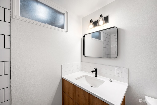 bathroom with vanity and tasteful backsplash