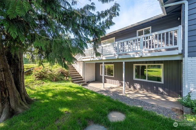 back of house featuring a yard, a patio, and a deck