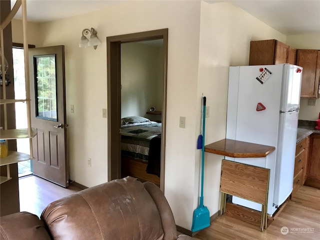 interior space with light hardwood / wood-style floors and white fridge