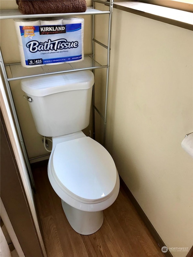 bathroom featuring toilet, wood finished floors, and baseboards