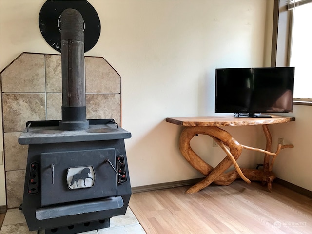 room details with hardwood / wood-style floors and a wood stove