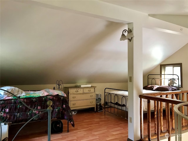 bedroom with light wood-type flooring and lofted ceiling