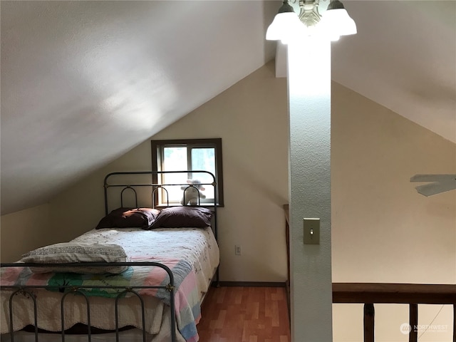 bedroom with vaulted ceiling and hardwood / wood-style floors