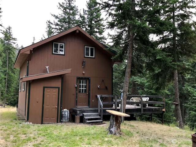 back of house featuring a lawn and a deck