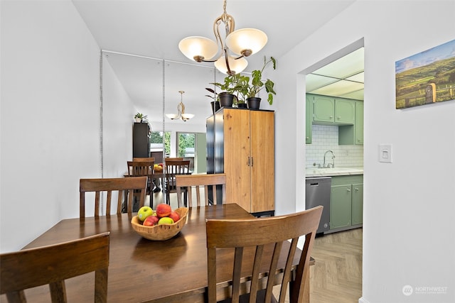 dining area featuring a notable chandelier, sink, and light parquet flooring