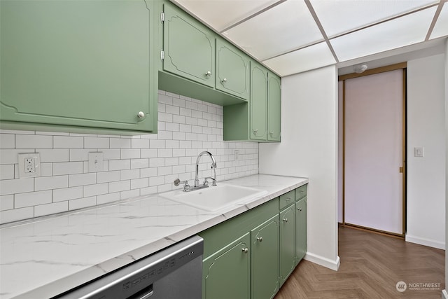 kitchen with dark parquet floors, sink, tasteful backsplash, green cabinetry, and dishwasher