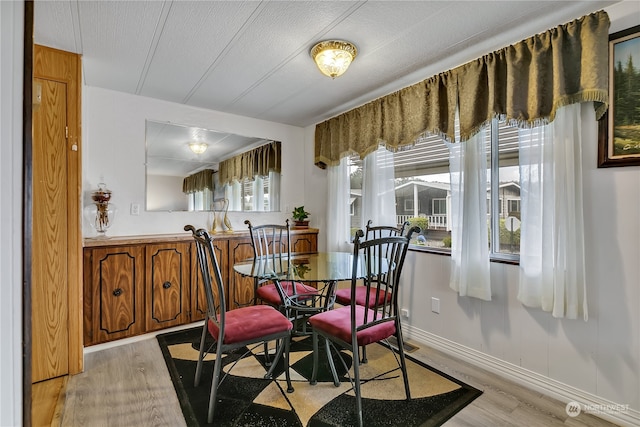 dining room with a textured ceiling and light hardwood / wood-style floors