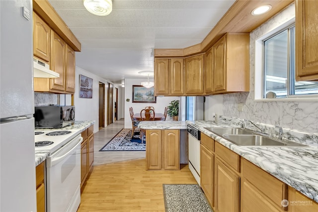 kitchen with white appliances, light hardwood / wood-style floors, sink, kitchen peninsula, and decorative backsplash