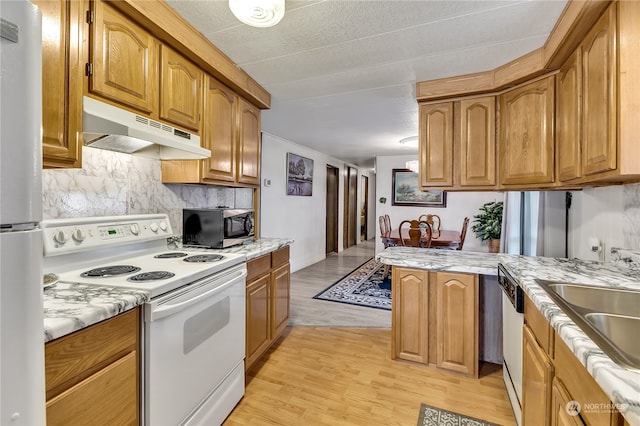 kitchen featuring a textured ceiling, white appliances, light hardwood / wood-style flooring, sink, and decorative backsplash