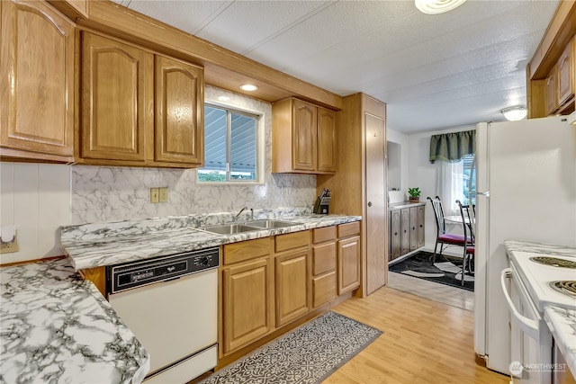 kitchen featuring backsplash, light wood-type flooring, sink, and white appliances