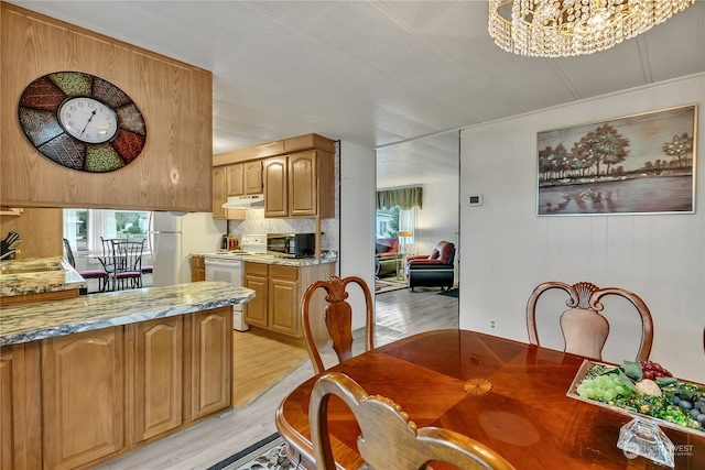 dining space featuring light hardwood / wood-style floors, an inviting chandelier, and sink