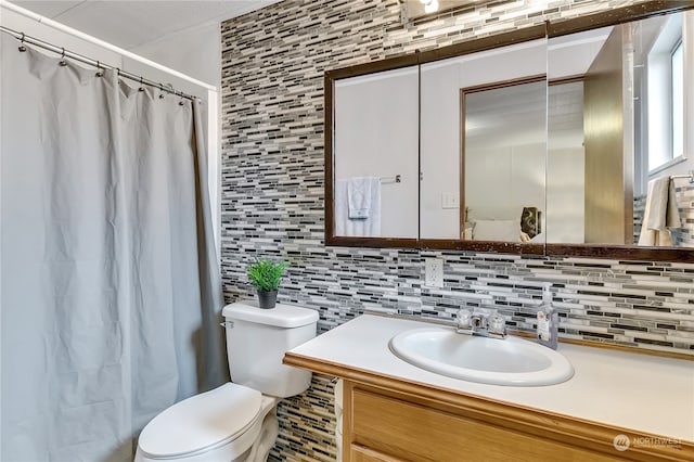 bathroom featuring vanity, toilet, decorative backsplash, and walk in shower