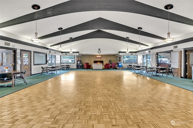 misc room with lofted ceiling with beams, plenty of natural light, brick wall, and light parquet flooring