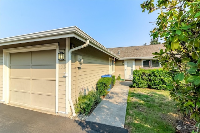 ranch-style house with an attached garage and a shingled roof