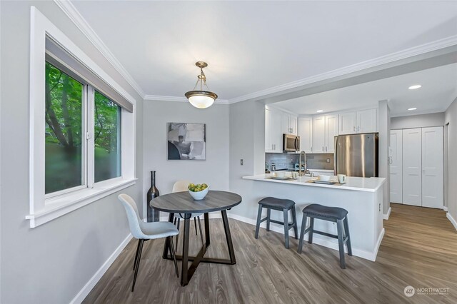 dining room featuring ornamental molding and wood-type flooring