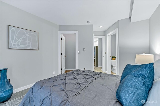 bedroom featuring connected bathroom and hardwood / wood-style floors