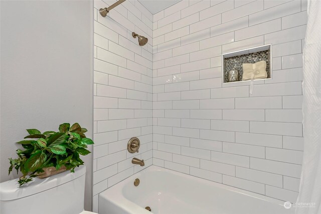 bathroom with tiled shower / bath and toilet