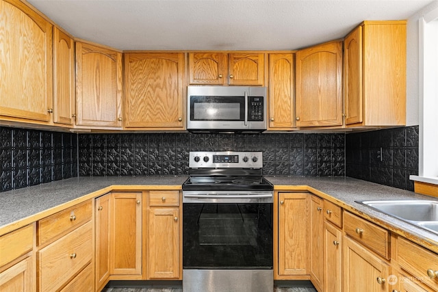 kitchen with appliances with stainless steel finishes and backsplash