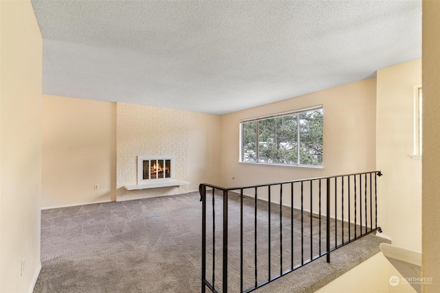 hallway featuring a textured ceiling and carpet floors