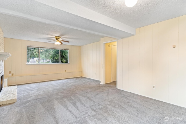 unfurnished living room featuring a textured ceiling, ceiling fan, light carpet, and a brick fireplace