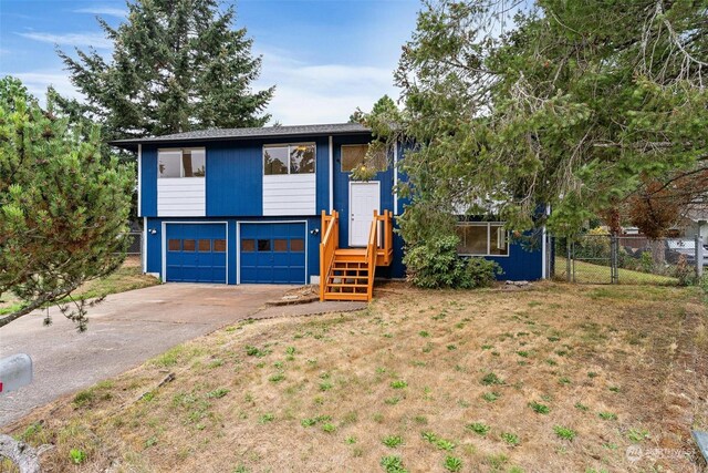 split foyer home featuring a garage and a front yard