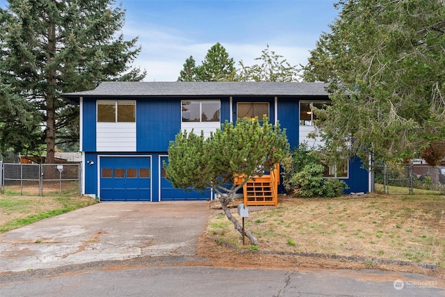 raised ranch with a garage and a front lawn