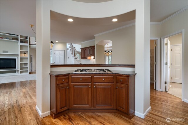 kitchen featuring light hardwood / wood-style floors, stainless steel gas stovetop, and ornamental molding