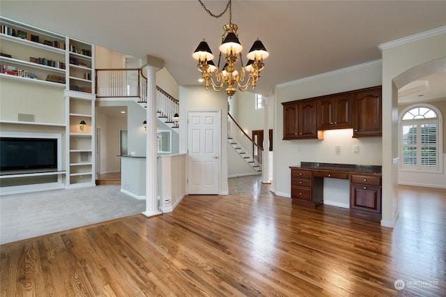 kitchen featuring built in desk, plenty of natural light, light wood-type flooring, and ornamental molding