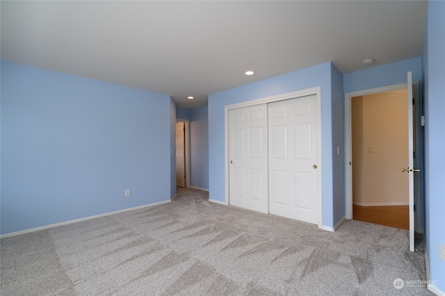 unfurnished bedroom featuring a closet and light carpet