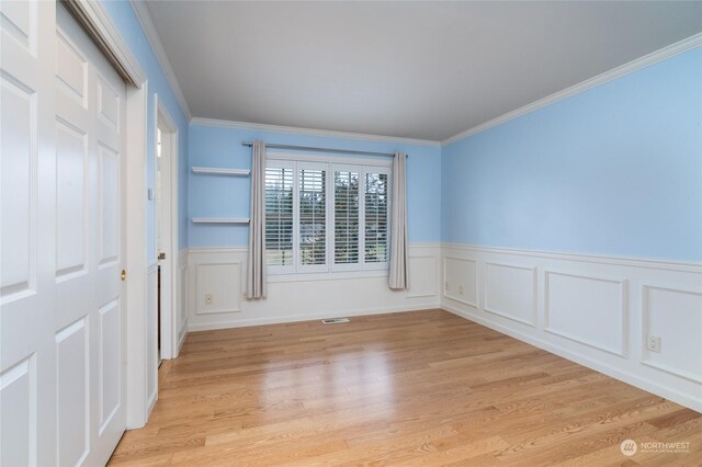 unfurnished room featuring ornamental molding and light hardwood / wood-style floors