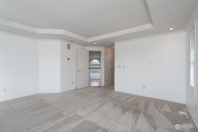 carpeted empty room featuring a wealth of natural light, visible vents, crown molding, and a raised ceiling