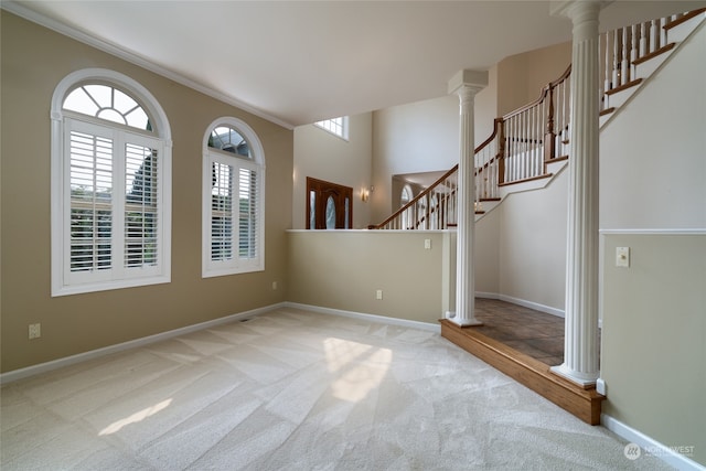 carpeted spare room with ornamental molding and decorative columns