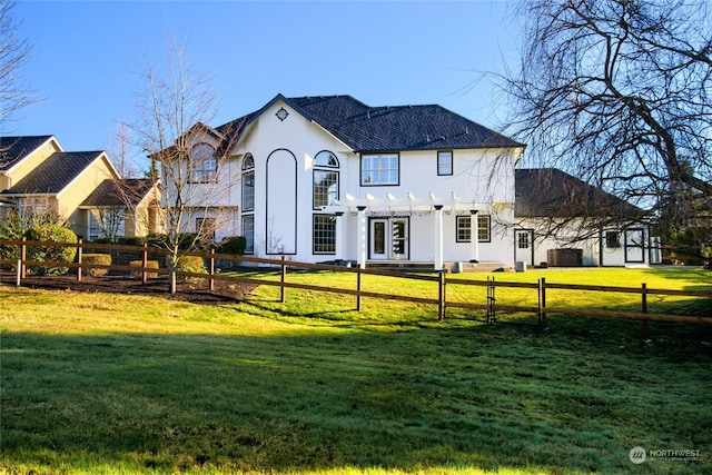 view of front of home with stucco siding, fence private yard, and a front lawn