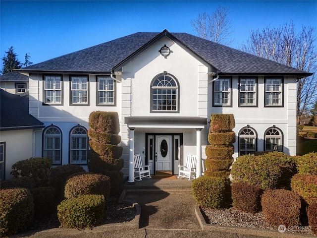 view of front of property with roof with shingles and stucco siding