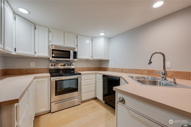 kitchen featuring light hardwood / wood-style flooring, appliances with stainless steel finishes, sink, and white cabinetry