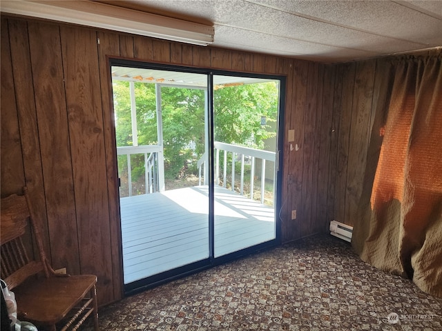 doorway to outside with wood walls and a baseboard radiator