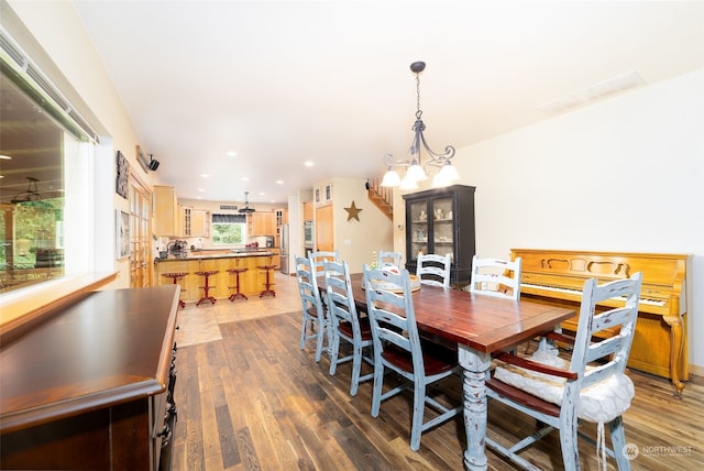 dining space featuring dark wood-type flooring and a chandelier