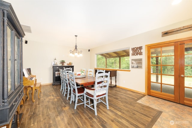 dining space featuring dark wood-type flooring, french doors, and an inviting chandelier