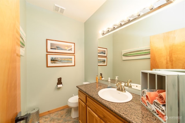 bathroom with tile patterned flooring, vanity, and toilet