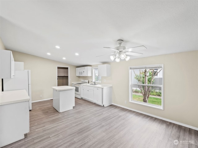 kitchen with light hardwood / wood-style floors, white appliances, a center island, and ceiling fan